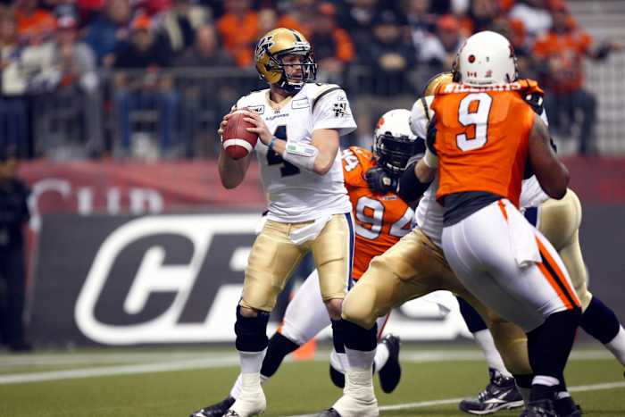 November 27, 2011; Vancouver, BC, Canada; Winnipeg Blue Bombers quarterback Buck Pierce (4) looks downfield as he gets pressure from BC Lions defensive tackle Khreem Smith (94) and defensive lineman Keron Williams (9) in the Grey Cup at BC Place Stadium. Mandatory Credit: John E. Sokolowski-USA TODAY Sports